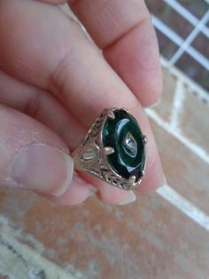 This is a vintage ring from a Berks county Pennsylvania estate. It is a size 7.5 and is sterling silver, but not marked. Has a green glass stone with a diamond chip in the middle. I have had different jewelry people tell me it looks Victorian and some say it is  from the 1960's and it is supposed to look older. Has a gold surface, but was probably dusted with gold. Nice condition.  Please don' t hesitate to ask questions. Happy collecting! Victorian Hallmarked Oval Enamel Ring, Victorian Oval Hallmarked Enamel Ring, Victorian Oval Enamel Ring For Anniversary, Antique Engraved Emerald Ring For Formal Occasions, Victorian Style Hallmarked Enamel Ring For Anniversary, Antique Oval Enamel Ring Collectible, Vintage Oval Engraved Emerald Ring, Silver Art Deco Emerald Ring, Antique Emerald Jewelry For Formal Occasions