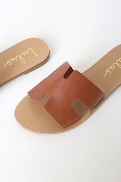 Lulus Exclusive! Add the Lulus Saxon Tan Slide Sandals to your ever-growing sandal collection for a touch of flair and style! Sleek faux leather creates a wide, cutout vamp strap, notched detail, and an open toe upper atop a 1.25" rubber heel. With its simple slide-on design, these sandals are essential for any babe on-the-go! 0. 25" rubber heel. Smooth insole. Rubber sole has nonskid markings. Man-made materials. Imported. Lulus | Saxon Tan Slide Sandal Heels | Size 9. Trendy Brown Leather Slides, Chic Brown Synthetic Slides, Modern Faux Leather Sandals For Summer, Chic Brown Slide Sandals, Summer Flat Faux Leather Mules, Chic Leather Lined Sandals For Vacation, Brown Open Heel Slides For Spring, Chic Summer Slides With Leather Lining, Spring Sandals With Leather Lining And Synthetic Material