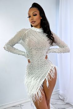 Long sleeve mesh mini dress featuring intricate pearl and rhinestone detail Asymmetrical hem with feather trimming No lining Back zipper closure Runs true to size 90% Nylon 10% Spandex Model is in size S Height: 5'7" Bust: 32" Waist: 26" Hips: 38"