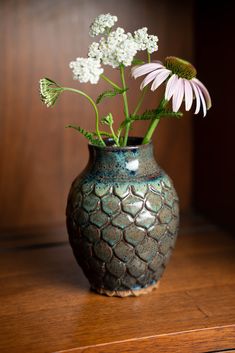 a vase with flowers in it sitting on a table