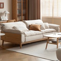 a living room filled with furniture and a window covered in shades of brown, white and tan