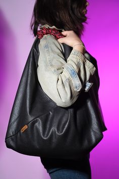 a woman carrying a black leather handbag on her shoulder