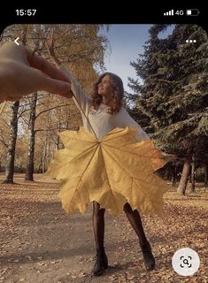 a woman is holding onto a large leaf