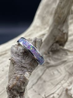 This beautiful handcrafted Stainless Steel comfort band is a real conversation starter! It features a Lavender Opal inlay in the center of the ring. The crushed Opal is placed by hand, incased in resin, and then finished and polished to a brilliant shine. Each ring I make is truly unique and no two are ever the same. These rings are made to order and are available in several sizes. Please allow 3-5 days for me to complete your ring. I do custom orders and if you have a different ring material or Artisan Rings With Inlay For Anniversary, Round Rings With Inlay Perfect For Gifts, Gift Round Ring With Inlay, Unique Thick Band Jewelry Gift, Adjustable Thick Band For Gift, Adjustable Thick Band Gift Bands, Handmade Thick Band Jewelry As Gift, Opal Inlay Ring Gift, Opal Ring With Inlay Perfect For Gifts