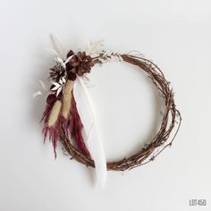 a wreath with feathers and flowers on it