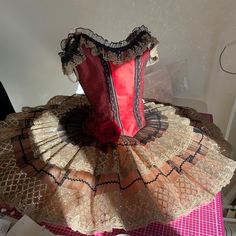 a red and gold dress sitting on top of a table