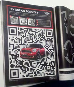 a red mini car sitting on top of a table next to a qr code