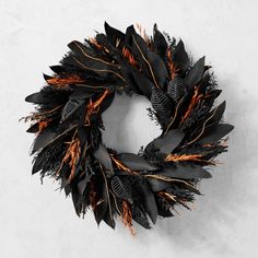 a black wreath with orange feathers on it