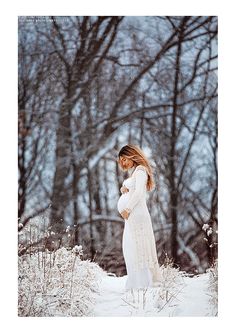 a pregnant woman standing in the snow