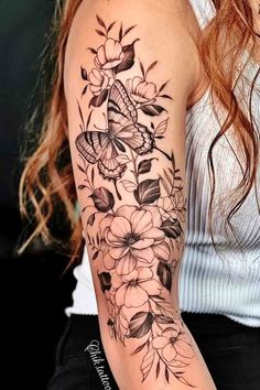 a woman with a butterfly and flowers tattoo on her arm