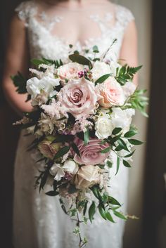 a bridal holding a bouquet of pink and white flowers