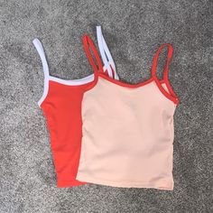 Brand: Rue21 Size: Extra Small (2) Material: Polyester Color: One Red, One Peach Condition: New Without Tags, Never Worn Comes With Two Of The Same Style Tank Tops. Casual Orange Seamless Tops, Sporty Orange Seamless Top, Sporty Seamless Orange Top, Red Seamless Cami Top, Red Sporty Crop Top For Spring, Sporty Red Crop Top For Spring, Red Color Block Tops For Summer, Trendy Red Seamless Tops, Red Ribbed Sleeveless Crop Top