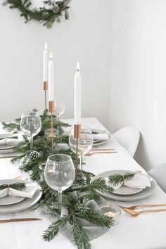 the table is set with candles, plates and silverware for an elegant christmas centerpiece