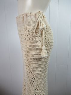 "Vintage 1970s hippy crochet skirt. Made of antique white cotton. Bohemian hippy style. Floor length with a drawstring waist. Crocheted on the bias so it is form fitting. Slight fish tail at bottom. No label. About a size medium. Actual measurements are: 32\"(adjusts bigger with drawstring) around the waist 38\" (stretches to 42\") around the hips 40\" overall length In very good condition." Beach Cotton Skirt With Crochet Trim, White Bohemian Bottoms With Crochet Trim, Cream Bohemian Bottoms For Vacation, Bohemian Cream Bottoms For Vacation, Hippie Cotton Maxi Skirt For Beach, Hippie Cotton Skirt For Beach, Bohemian Crochet Lace Bottoms For Festival, Bohemian Cotton Maxi Skirt For Beach, Bohemian Crochet Lace Beach Bottoms