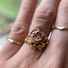 a close up of a person's hand with a gold ring on their finger