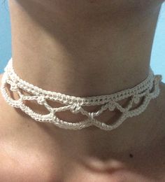 a woman wearing a white crochet choker with an intricate design on it