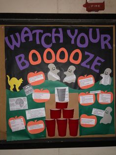 a sign that says watch your booze with red cups in front of it and halloween decorations