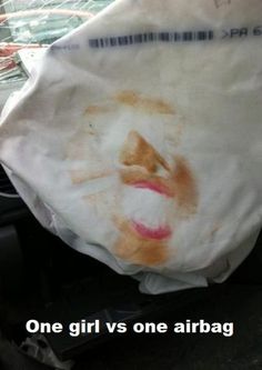 a paper bag with a face drawn on it sitting in the front seat of a car