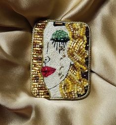 a close up of a purse with beads on the bottom and an image of a woman's face