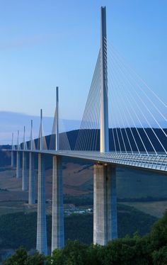 an image of a bridge that is going over the water and hills in the background