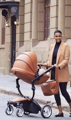 a woman standing next to a baby carriage