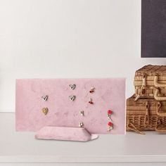 there is a pink shelf with earrings on it