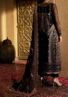 Introducing our Winter collection 'VELVET FESTIVE' by Asim Jofa designed to make you look and feel your best these pieces will add a touch of class and elegance to your wardrobe. In a captivating dance of colors and motifs, this onyx elite ensemble unfolds like a love story waiting to be told. It's a masterpiece embroidered with intricate motifs, where threads of gold are echoing the ancient art of Meenakari. These motifs breathe life into the attire, a tribute to the rich flora and fauna of South Asia, painting a vivid picture of nature's abundance. The shirt and dupatta, born of the same fabric, share a secret world adorned with delicate cupped sequins, zari, and threads in the hues of magenta and green. The borders of the hem, sleeves, and shirt, cloaked in sumptuous velvet, bring an el Black Long Sleeve Georgette Dress, Multicolor Georgette Dress For Festivals, Multicolor Georgette Festival Dresses, Black Georgette Party Dress, Elegant Dresses With Dabka For Transitional Seasons, Evening Dress With Sheer Dupatta For Festivals, Transitional Anarkali Dress In Georgette, Multicolor Georgette Dress With Dabka, Multicolor Georgette Dabka Dress