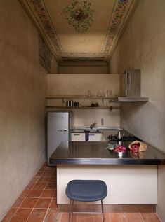 a small kitchen with an island counter and tile flooring