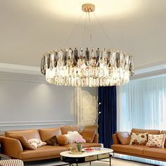 a living room filled with furniture and a chandelier hanging over the couches