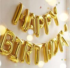 gold foil balloons that spell out the word happy birthday