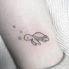 a small turtle tattoo on the left thigh and right leg, with bubbles coming out of it