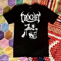 "'Crochet' unisex t-shirt. Brand new design! It features a young crochet fan repairing her teddy bear while her moggy looks on ominously! All our Red Mutha prints are designed by us and are exclusive to us. Tees are 100% ring-spun cotton, Hand screen printed by our team in Hove. We offer 4 sizes,it's best to check the measurements to see which is the best fit for you: Small-Chest 35\",Shoulder to Shoulder 15.5\",Centre Back 27\" and Bottom Hem 36\". (Size 10) Medium-Chest 38\",Shoulder to Should Fitted Cotton Emo T-shirt, Black Crochet Cotton Top, Goth Knitting, Crochet Fan, Metal Goth, Hobby Craft, Wool Cat, Craft Knitting, Rock Metal