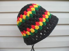 a multicolored crocheted hat hanging from a hook