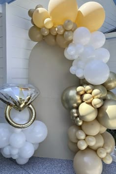 balloons and rings are hanging from the side of a wall in front of a house