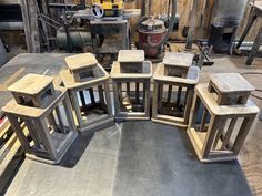 a group of wooden lanterns sitting on top of a metal floor next to a pile of wood