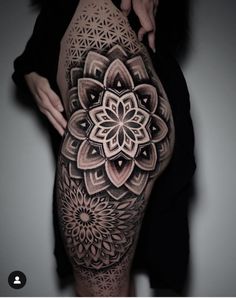 a woman's thigh with an intricate flower tattoo on it