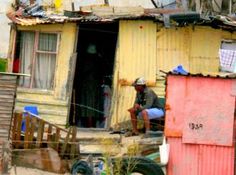 a man sitting on the porch of a shack