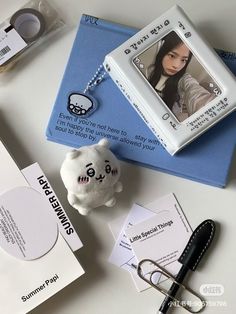 a white stuffed animal sitting on top of a table next to other items and papers