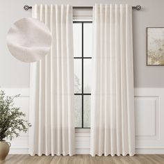 a white curtain hanging on the side of a window next to a potted plant