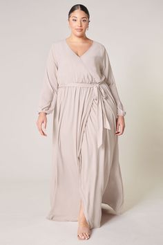 Warm and inviting, the Wholehearted Maxi Dress is a perfect combination of modest and sultry. Long balloon sleeves frame a surplice neckline separated by a tie at the waist, creating a forgiving faux wrap. The skirt maintains an airy and flowy shape that trails behind as you walk down the aisle. - Chiffon- Faux wrap- Keyhole- Elastic waist- Comes in 14 ColorsSize + Fit - Model is 5'9" and wearing size 2X- Measurements taken from size 2X - Chest: 36 1/2"- Length: 66" Fabric Self: 100% PolyesterLi Flowy Belted Wrap Dress With Surplice Neckline, Flowy Wrap Dress For Fall, Flowy Wrap Dress With Tie Waist, Flowy Faux Wrap Maxi Dress, Flowy Faux Wrap Dress, Flowy Faux Wrap Dress With Surplice Neckline, Flowy Faux Wrap V-neck Maxi Dress, Flowy Wrap Dress With Faux Wrap And Surplice Neckline, Flowy Wrap Dress For Date Night