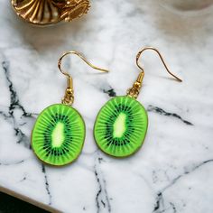 Handmade kiwi earrings. Lovely fruity earrings. All our jewellery is hypoallergenic. Made with loving care in Chichester.  All orders come packed within a lovely Oganza bag. Length - 4cm Width - 2cm Made to order and dispatched in one working day. Free standard 2nd class delivery. Upgrade to 1st class for 90p with our express delivery service. Any questions always feel free to ask, I will respond back very quickly. Thank you ❤️ Green Dangle Novelty Jewelry, Green Novelty Dangle Jewelry, Cadmium-free Green Jewelry For Gifts, Kiwi Earrings, Kiwi Slice, Fruit Earrings, Earrings Summer, Chichester, A Bracelet