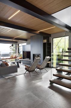 an open living room with stairs leading up to the second floor