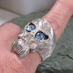 This looks like a handmade piece. I believe it is sand or tufa cast. 38.6 grams sterling silver skull ring, blue CZ eyes, size 12 1/2 on the mandrel, handmade, cast, vintage. The top of the ring measures 1.3 inches long. It is unmarked for silver content.  I used acid testing to determine that it is sterling silver. See pictures of the test. It turned a bright red which indicates sterling. Nickel would have turned dark green or black. Guaranteed sterling. PLEASE CHECK THAT IT WILL FIT BEFORE ORDERING.  Thank you.   For more sterling jewelry from MontanaPrairie, follow this link to my Etsy shop.  MontanaPrairie.etsy.com  All my jewelry is pre-owned, vintage or antique and MAY SHOW NORMAL WEAR.  It may (and probably will) need a little polishing to remove tarnish, but if there are any major Sterling Silver Skull Rings, Silver Skull Ring, Tarnish Remover, Sterling Jewelry, Ring Blue, Skull Ring, 2 On, Bright Red, Rings Statement