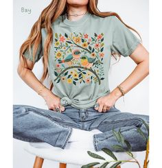 Elevate your wardrobe with this whimsical birds and flowers t-shirt, featuring a stunning nature-inspired graphic. This colorful botanical art print adds a cute and vibrant touch to any outfit. *🌿 High-quality graphic t-shirt with a whimsical bird and floral design *🐦 Made from soft, comfortable fabric perfect for everyday wear *🌸 Available in multiple sizes and colors to suit your style *👕 Durable print that stands up to washing and regular use *🎁 Great gift idea for bird lovers, nature en Nature-inspired Summer Tops With Plant Print, Nature-inspired Tops With Plant Print For Summer, Summer Nature-inspired Tops With Plant Print, Nature-inspired Relaxed Fit Short Sleeve Tops, Nature-inspired Cotton Tops With Graphic Print, Nature-inspired Cotton T-shirt For Spring, Casual Summer Tops With Bird Print, Casual Crew Neck T-shirt With Bird Print, Casual Bird Print Tops For Summer