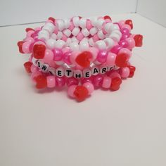 pink and white bracelets with red hearts on them that say sweet the heart together