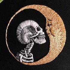 a skeleton sitting on top of a crescent with the moon in the middle and one eye open