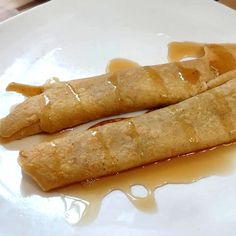 two crepes on a white plate with caramel sauce