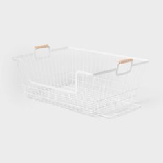 a white wire basket with wooden handles