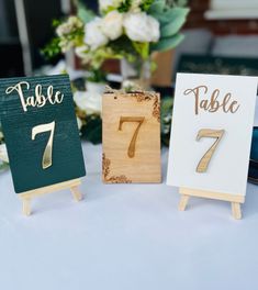 three wooden table numbers sitting on top of a white table