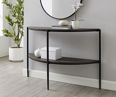 a round mirror sitting on top of a wall next to a shelf with vases